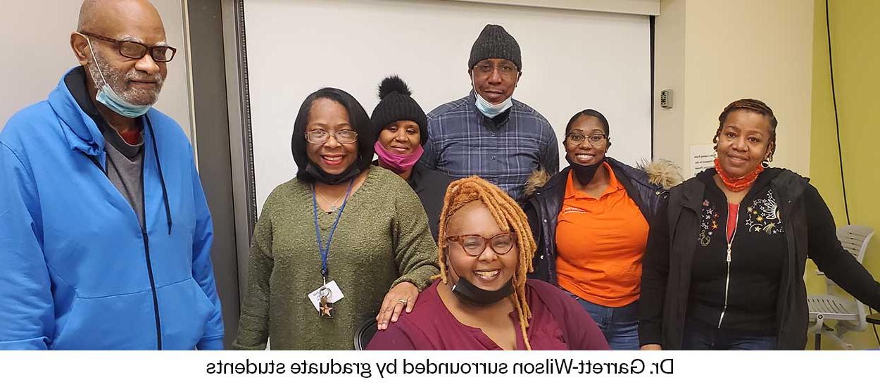 Dr. Garrett-Wilson surrounded by graduate students